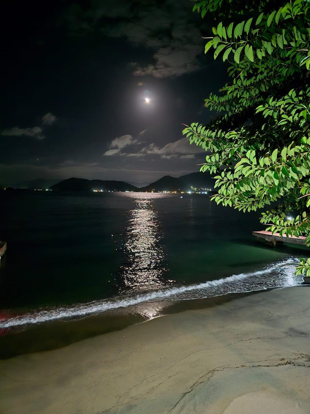 Luar refletindo na água em frente à pousada