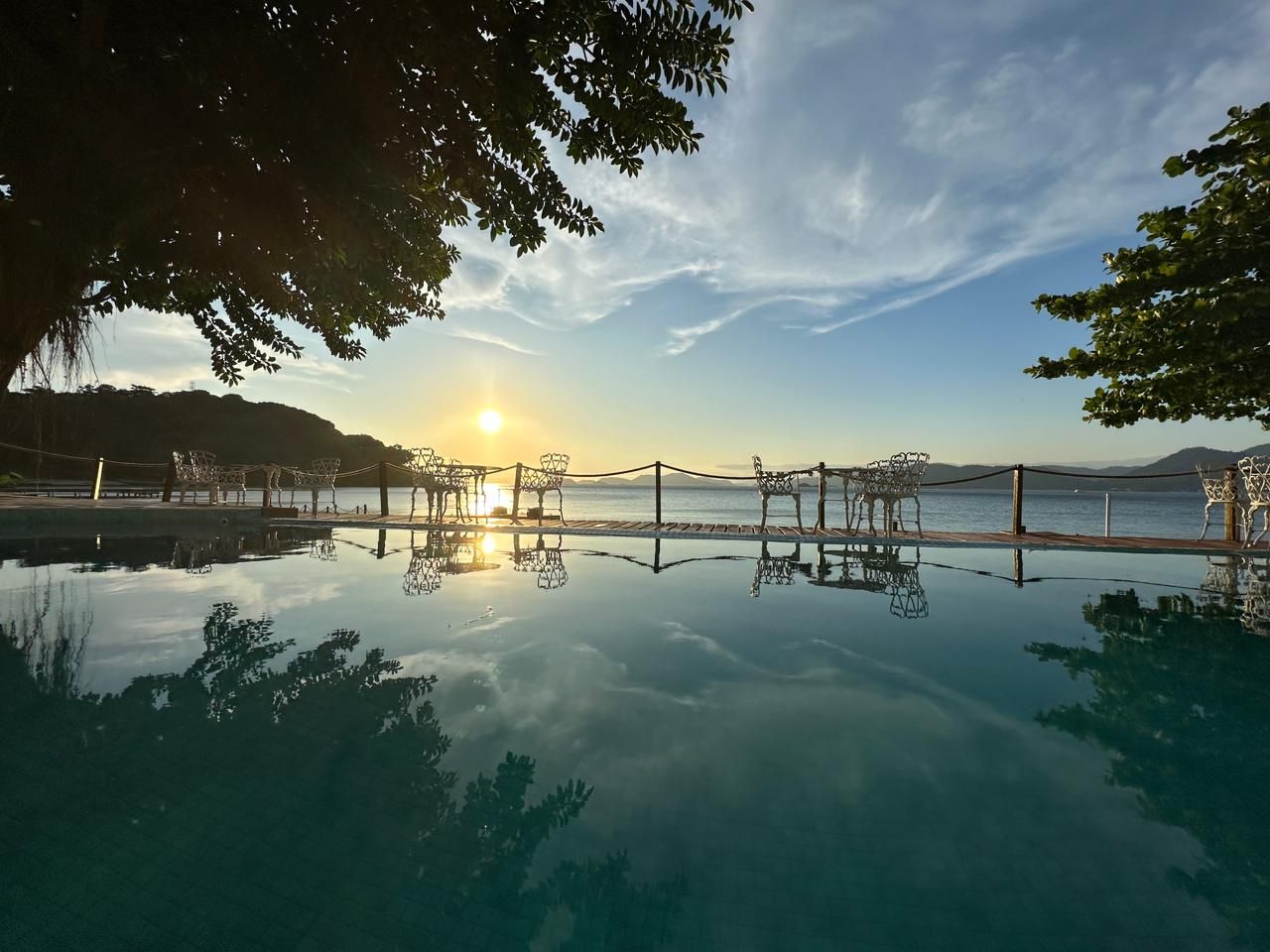 Piscina da pousada ao entardecer, de frente para o mar